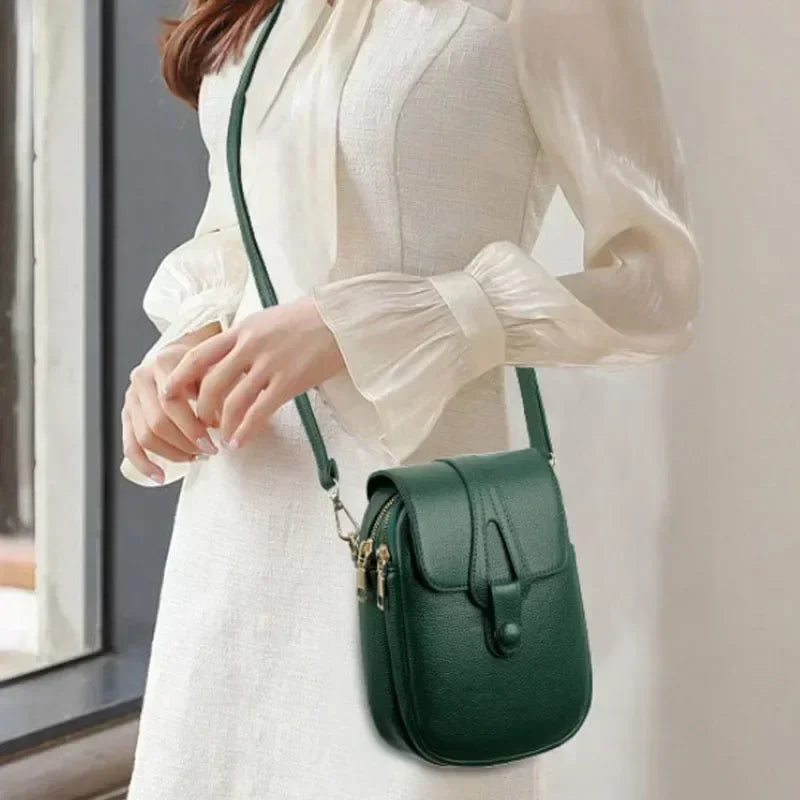 Small crossbody handbag in green with flap front, gold hardware, and shoulder strap