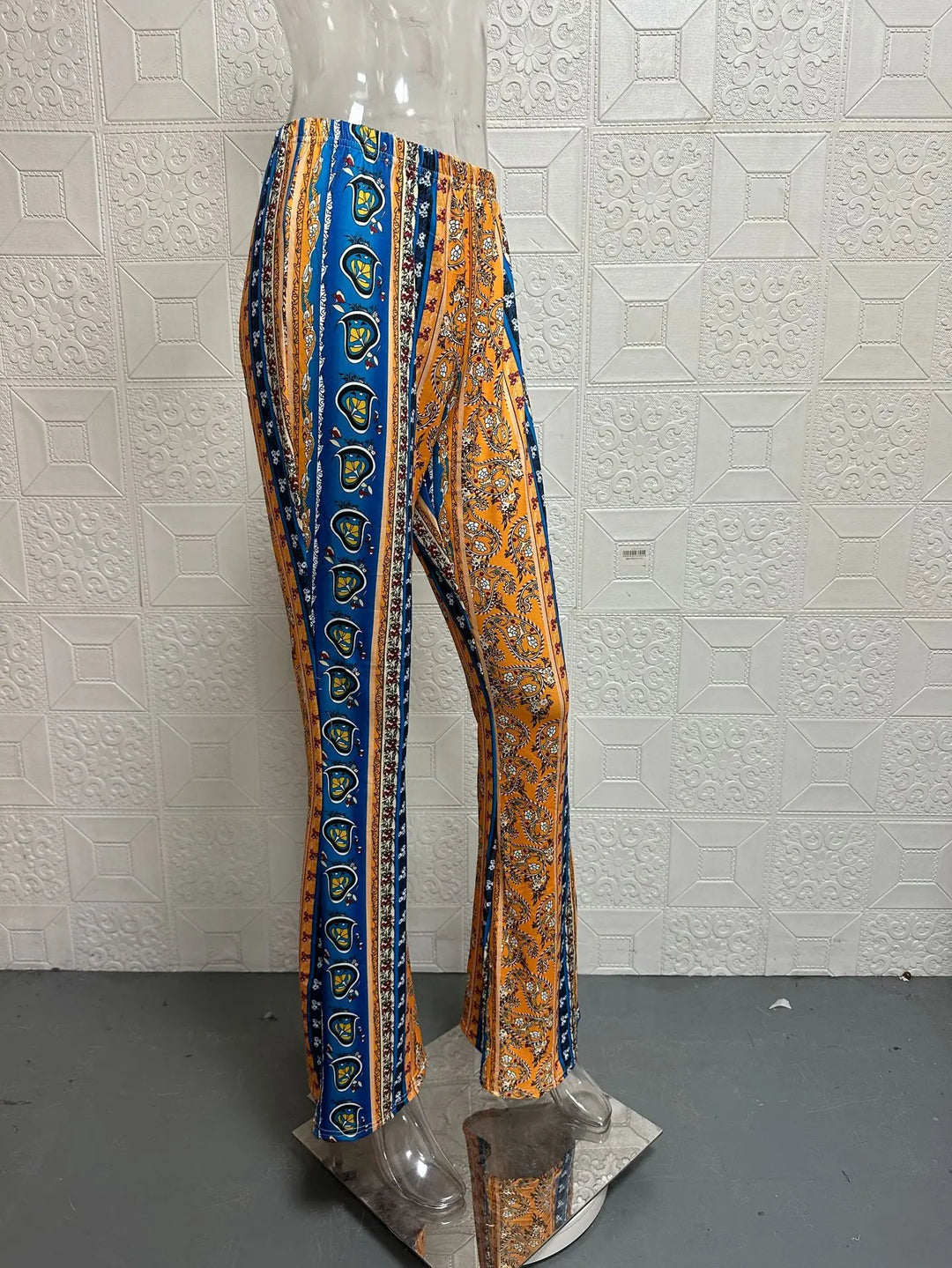 Low-waist flare pants with orange, blue, and gold vertical striped paisley print