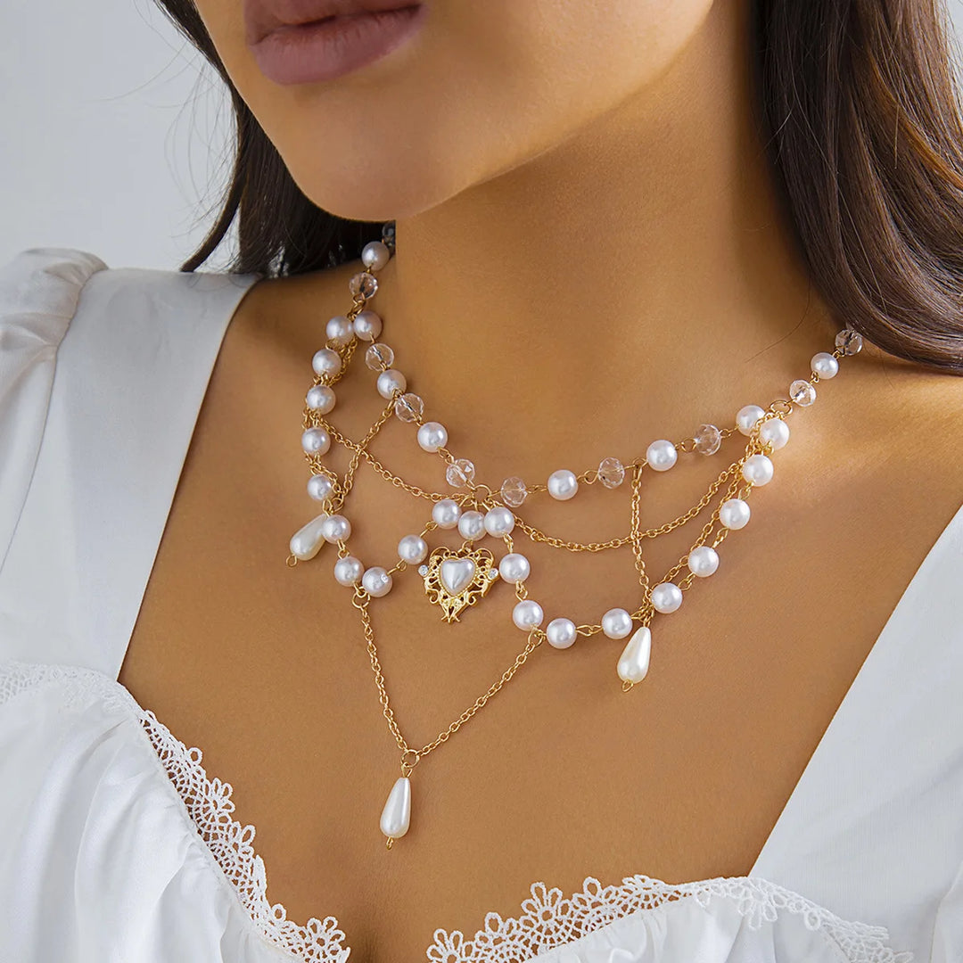 Ivory pearl layered necklace with crown-and-drop pendant and gold-tone chains