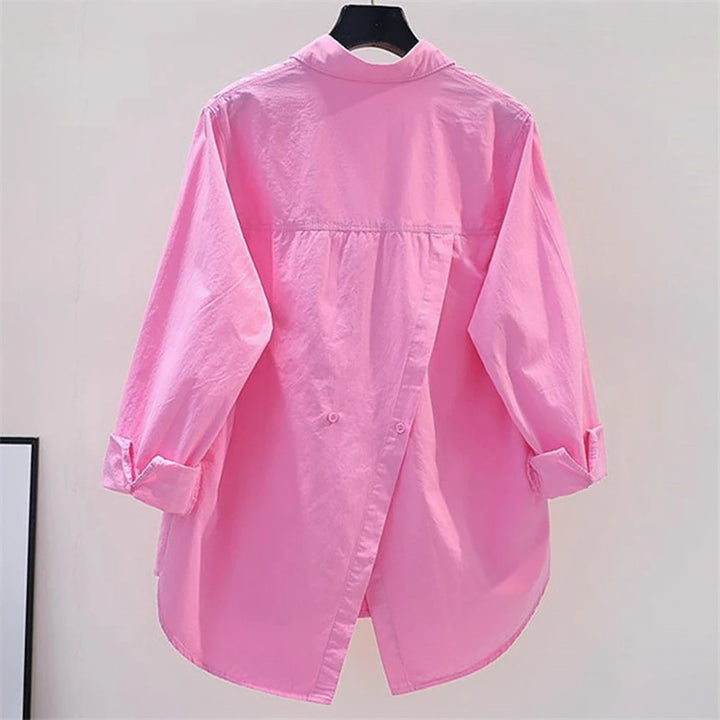 Pink shirt on a hanger against a plain background