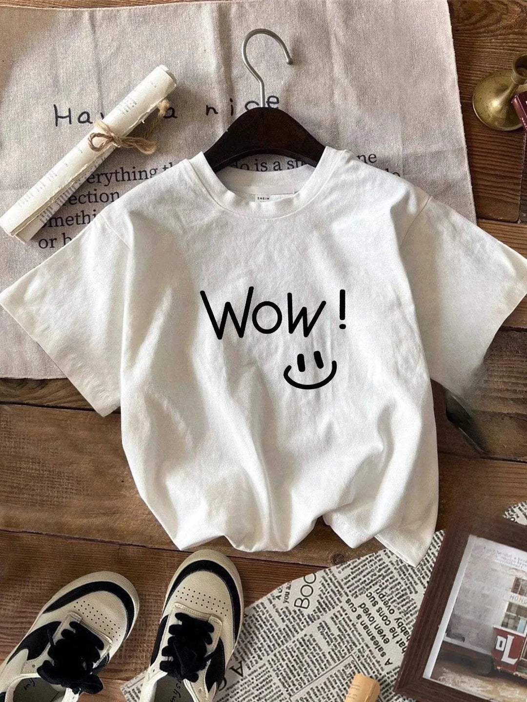 White plus size graphic tee with “Wow!” smiley face front graphic