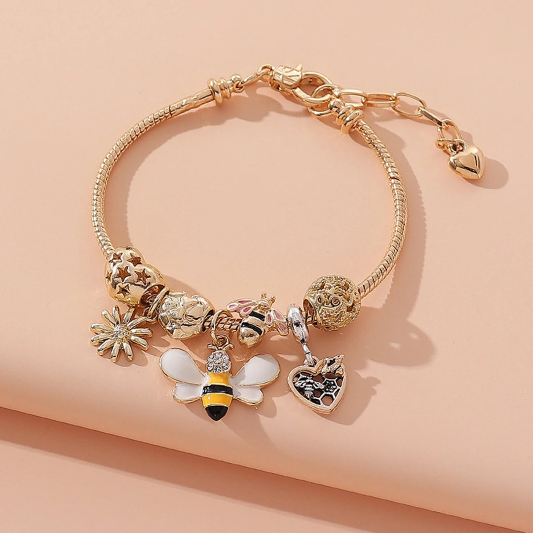 Gold-tone charm bracelet with clover, bee, and heart dangle charms