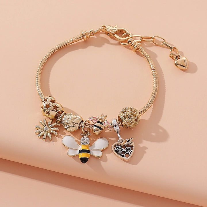 Gold-tone charm bracelet with clover, bee, and heart dangle charms