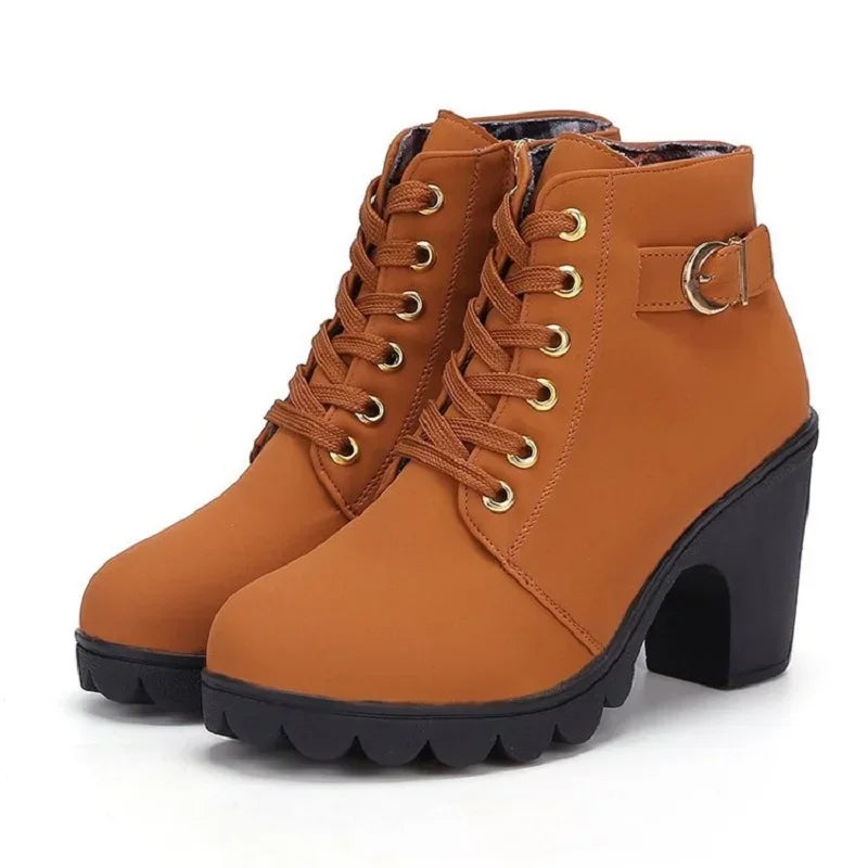 Brown ankle boots with black soles on a white background