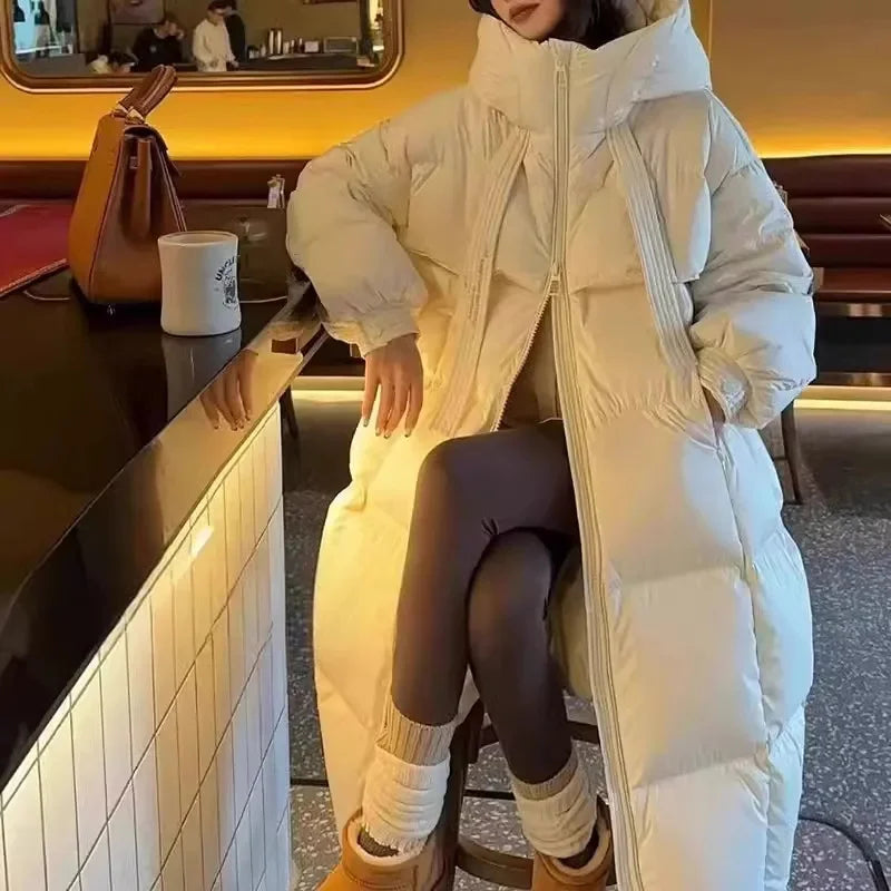 Person wearing a long white puffer coat sitting at a counter.