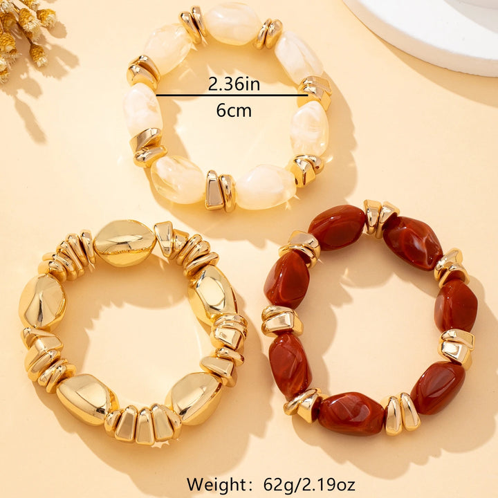 Flat-lay gold-tone acrylic bead bracelets with cream and deep red irregular beads