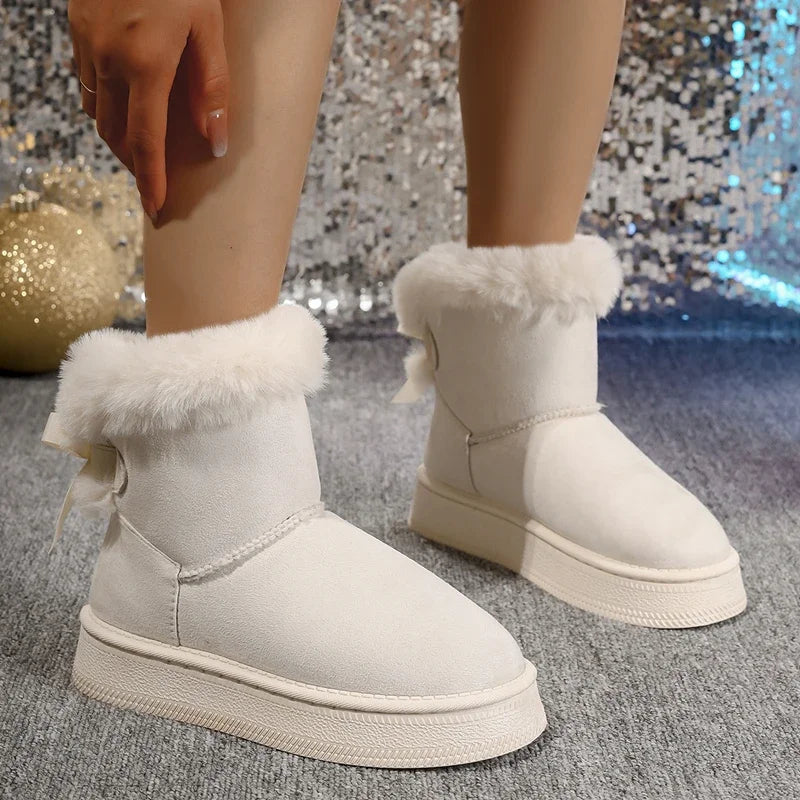 White winter snow boots with round toe, plush fur trim, and small bow on the cuff