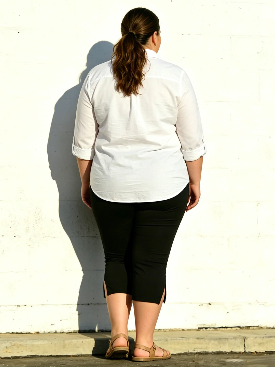 Black high-waist capri leggings, back view with side slits