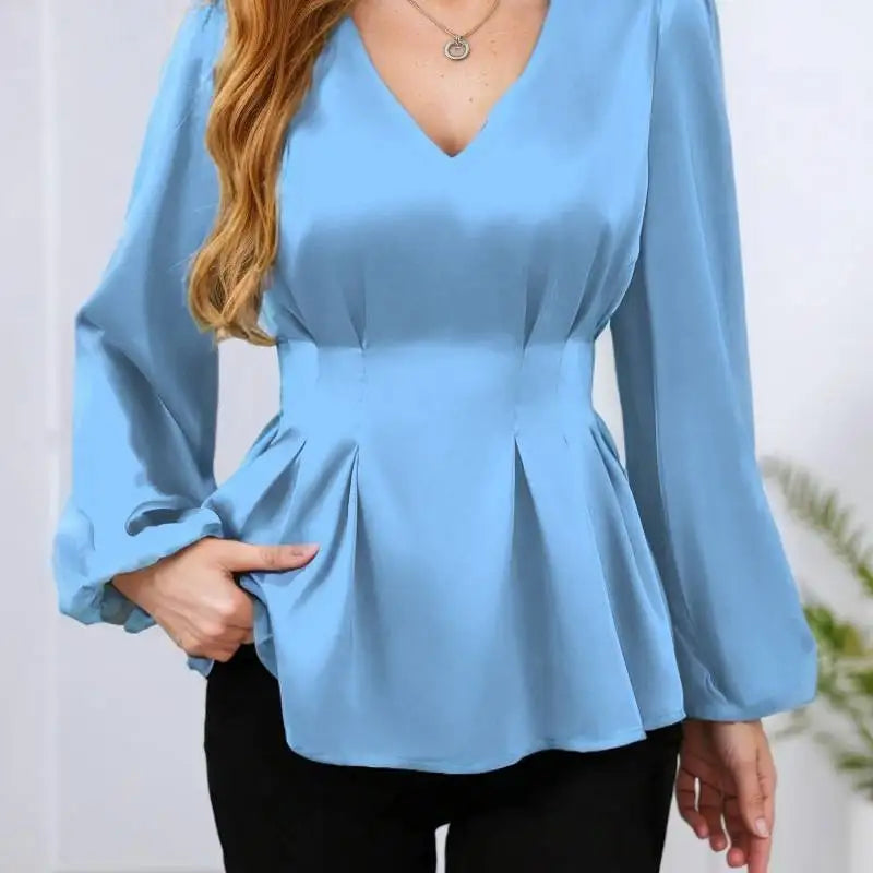Light blue peplum top worn by a person with a blurred background