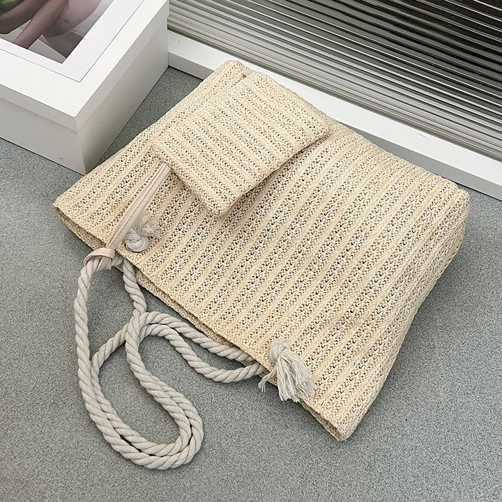 Beige woven bag with a rope handle on a gray surface