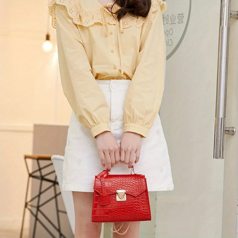Person holding a red handbag wearing a yellow top and white skirt.