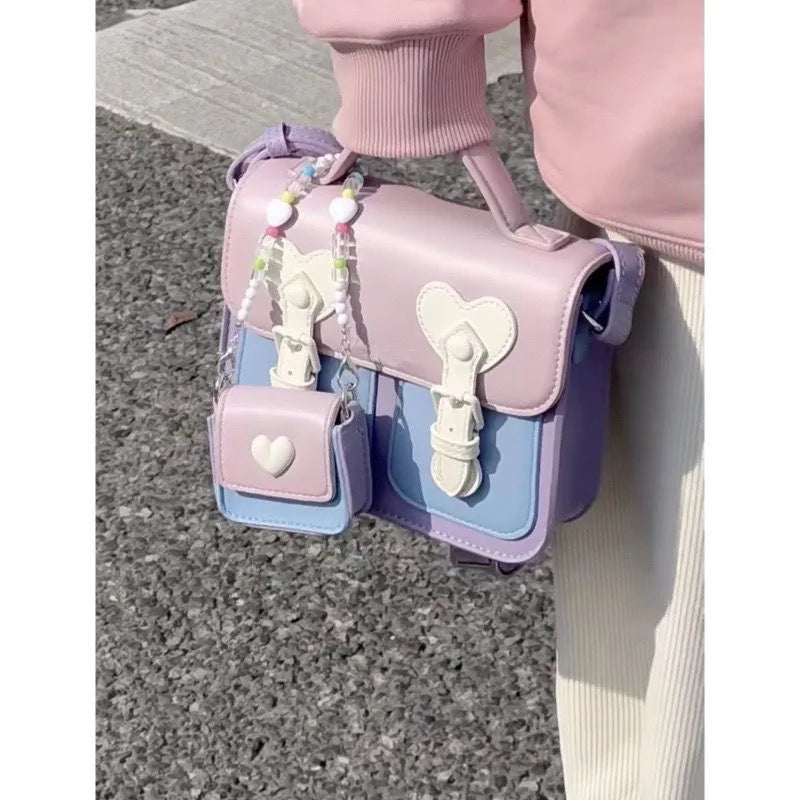 Pastel women’s shoulder handbag with heart flap, tassel charms, and small side pouches