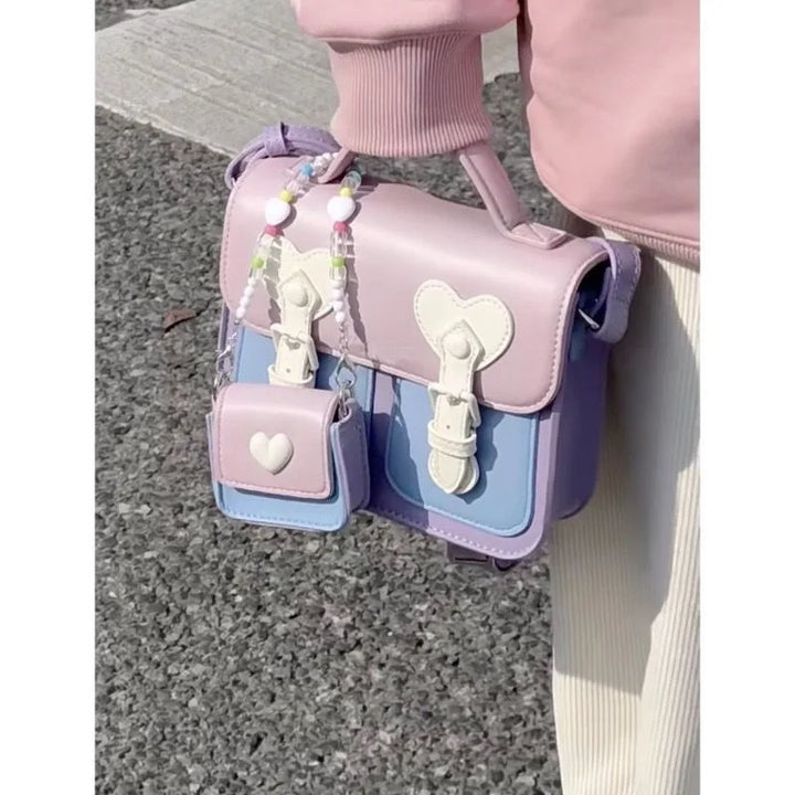 Pastel women’s shoulder handbag with heart flap, tassel charms, and small side pouches