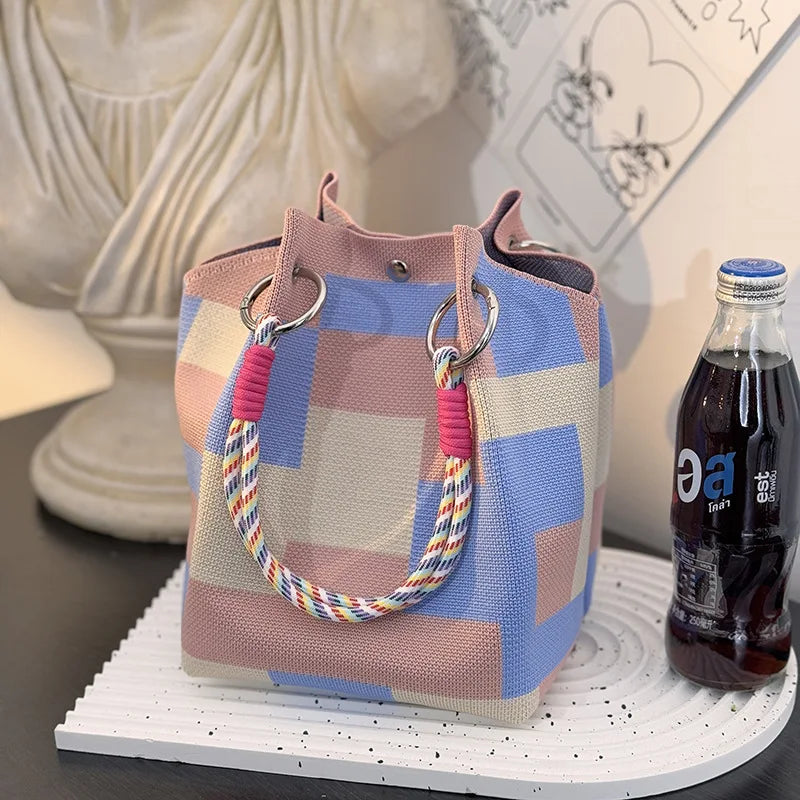 Blue and pink striped top-handle satchel with braided rope handles and metal rings