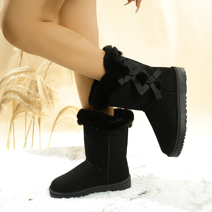 Black mid-calf platform snow boots with plush faux-fur lining and side ribbon bows