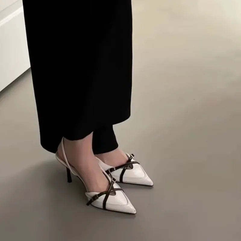 Women’s light beige pointed-toe slingback heels with black cross straps and stiletto