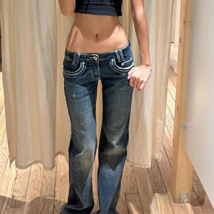 Retro blue slim-fit low-rise jeans, close-up of waist with belt loops and front hardware