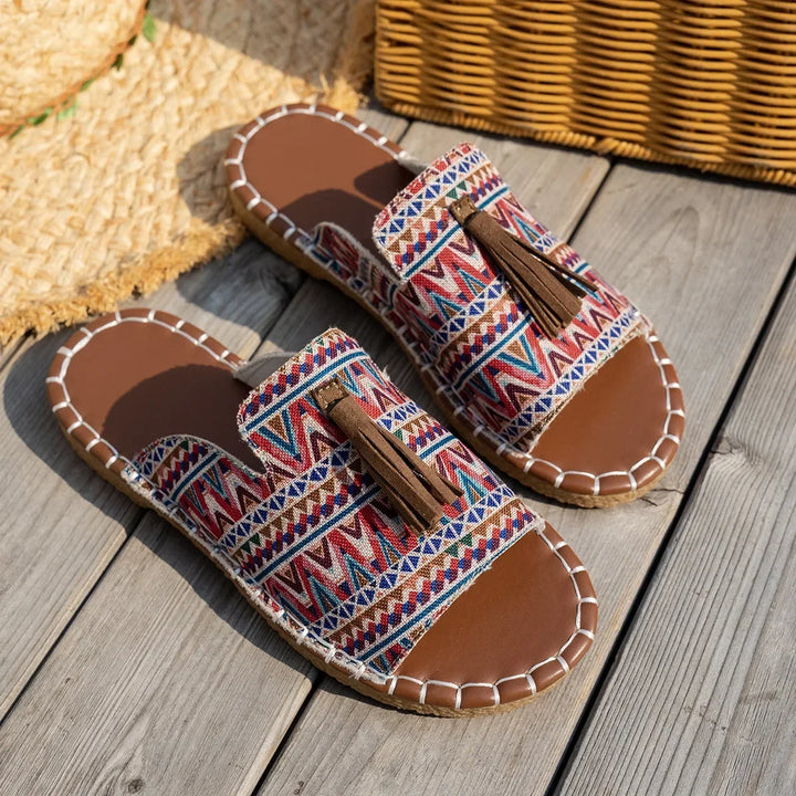 Pair of sandals with tribal patterns on a wooden surface