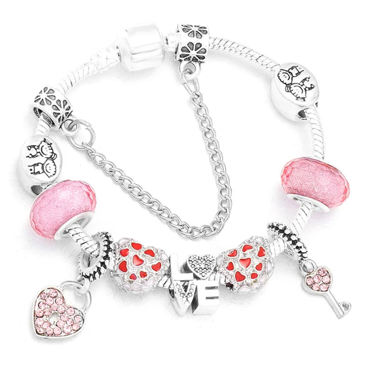 Silver-tone bracelet with pink bead caps, heart charms, and small crystal accents