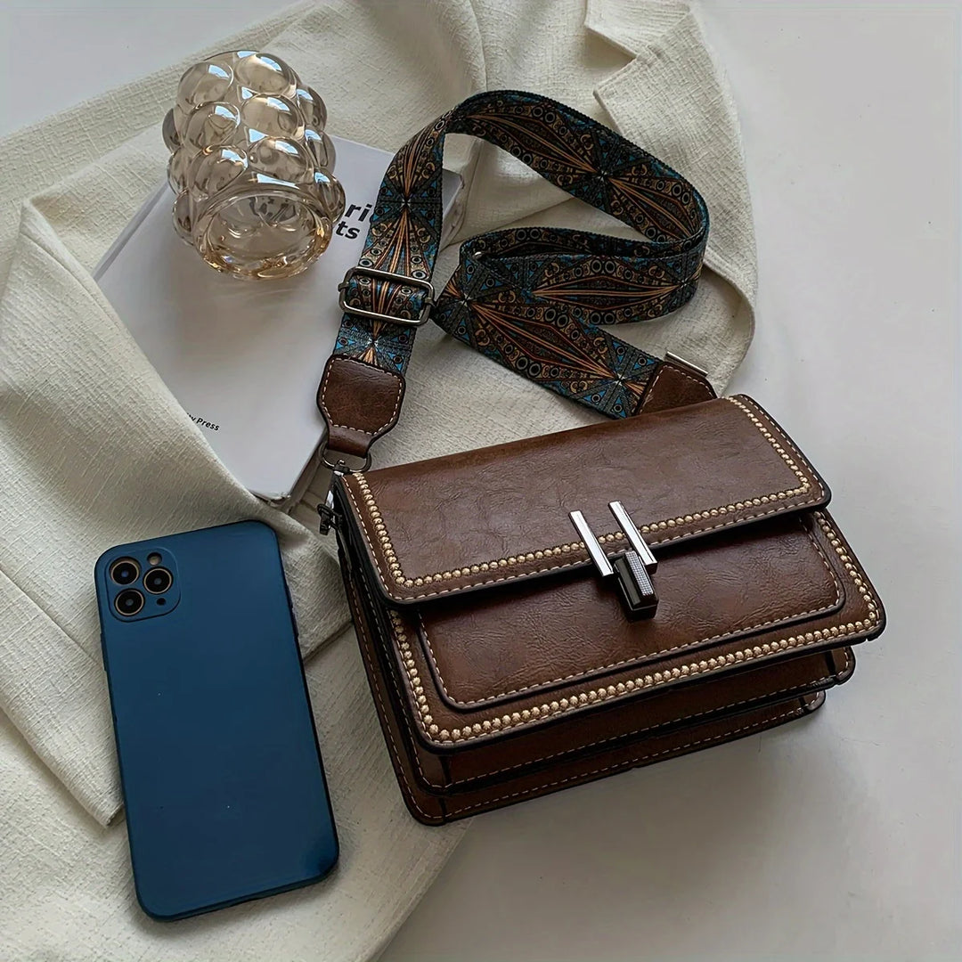 Mini crossbody bag in brown with flap lock, beaded edge trim, and patterned strap