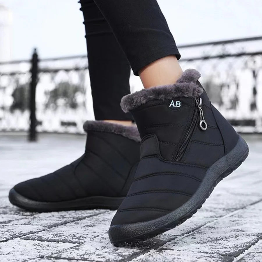 Black winter boots with fur lining on a snowy ground