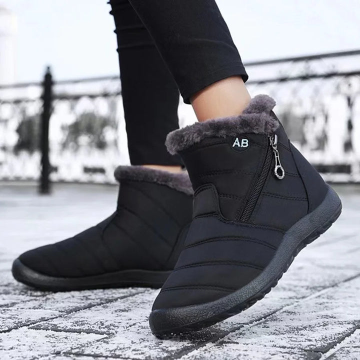 Black winter boots with fur lining on a snowy ground