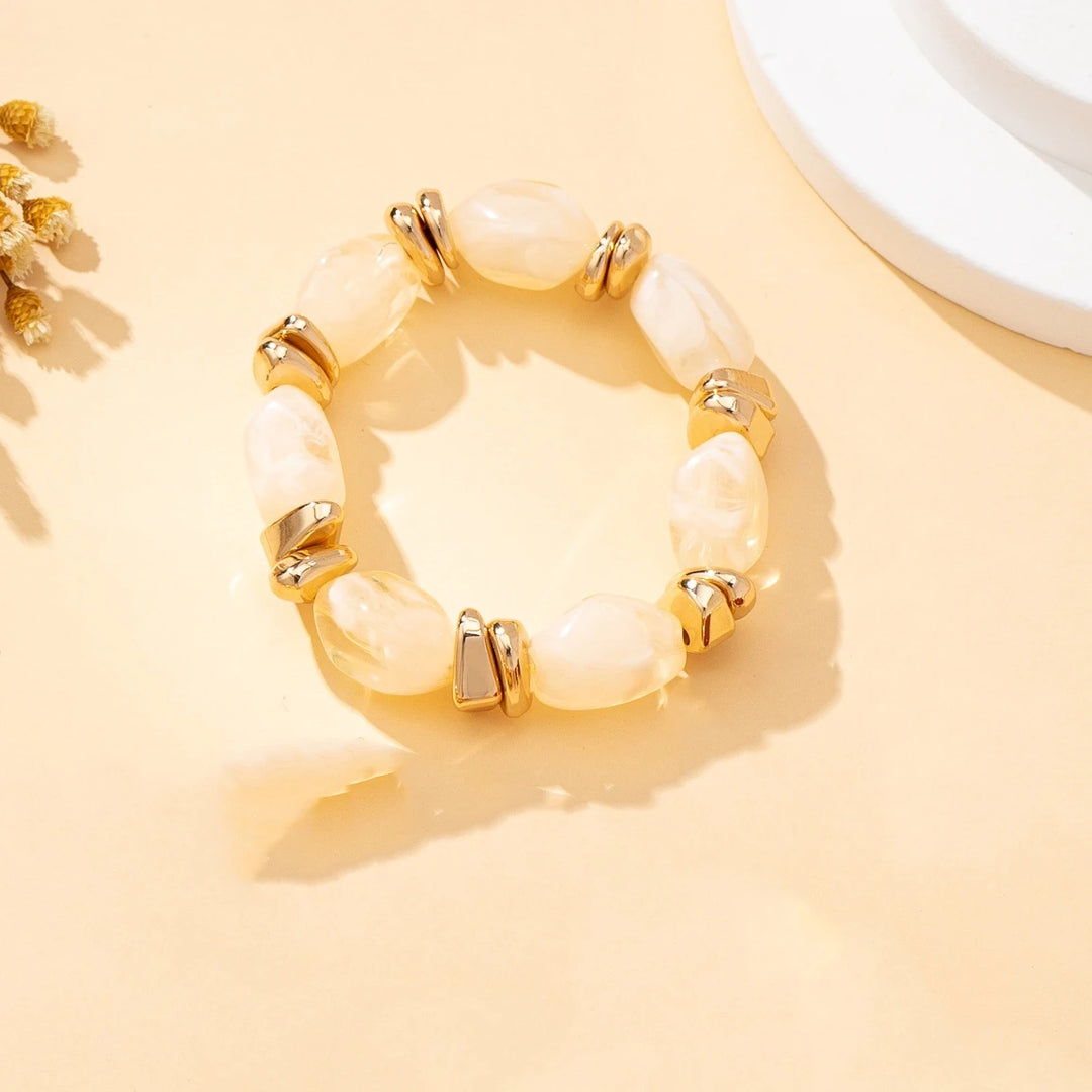 Gold-tone acrylic bead bracelet with cream/ivory irregular beads and chunky link accents