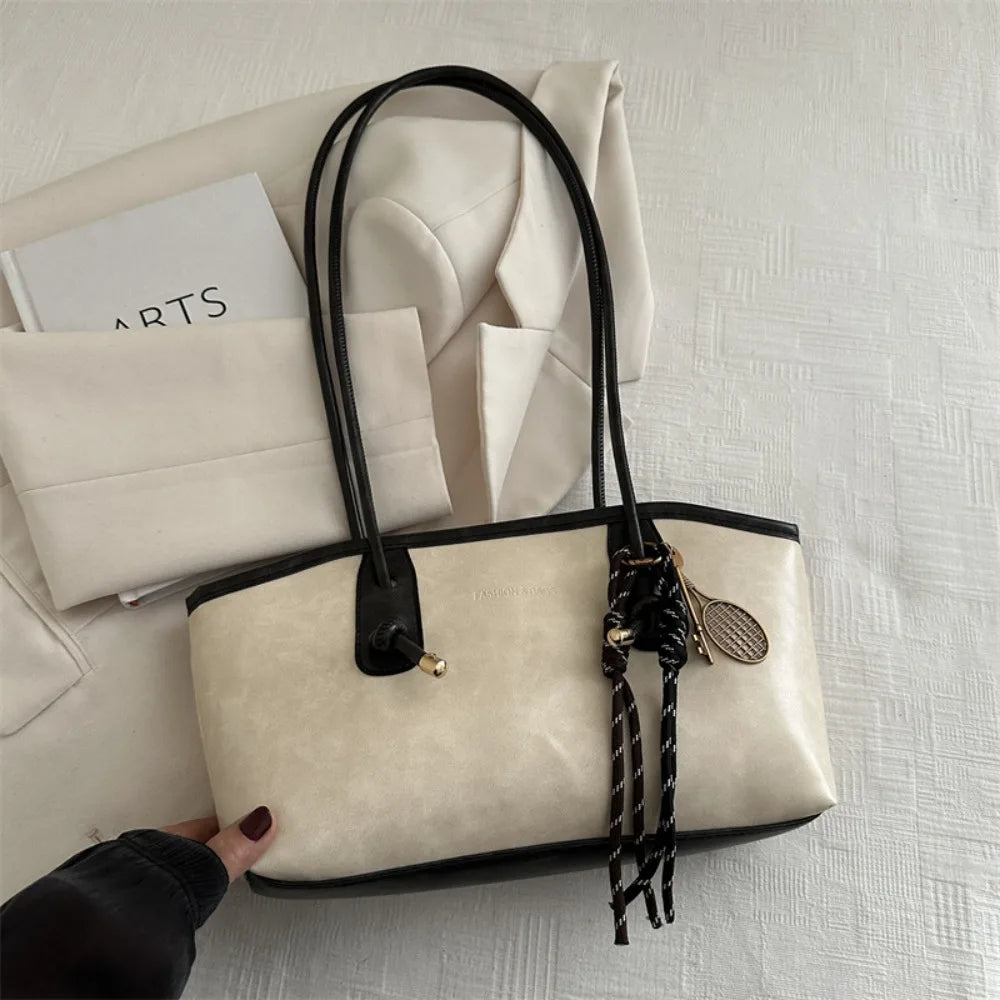 Cream PU leather tote handbag with black handles and braided crossbody tassel charm