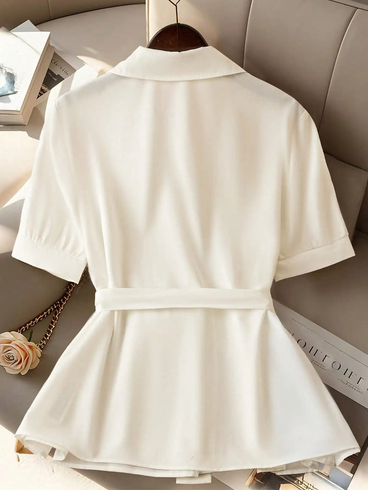 White short-sleeve button-up shirt with turn-down collar and belted pleated hem, back view