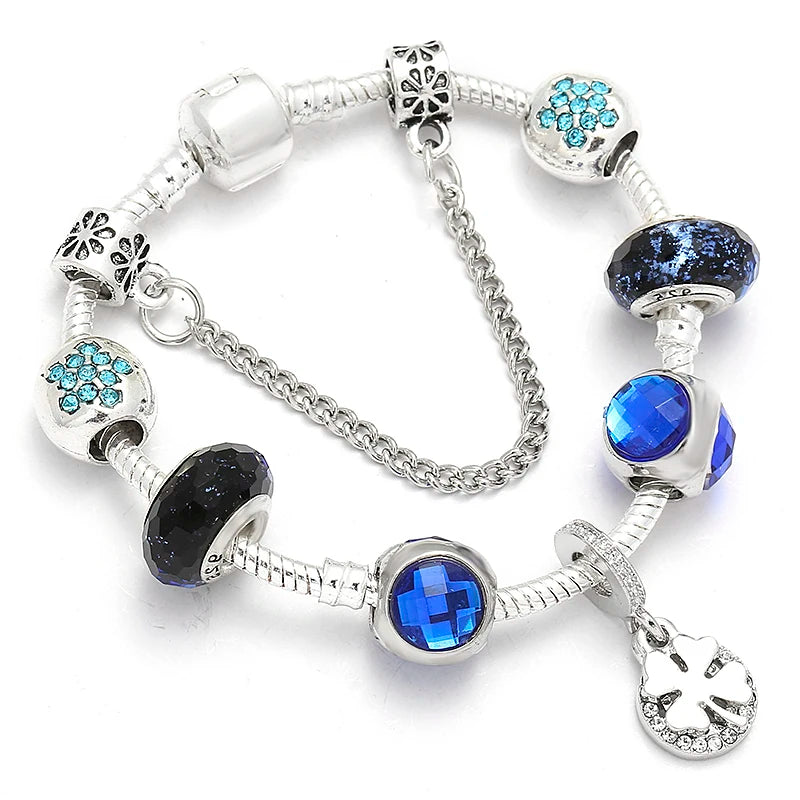 Silver bracelet with blue crystal beads, snowflake spacers, and cat-heart charm