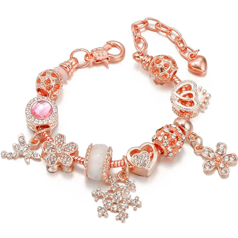 Rose gold charm bracelet with pink crystal beads, flower accents, and dangling snowflake charm