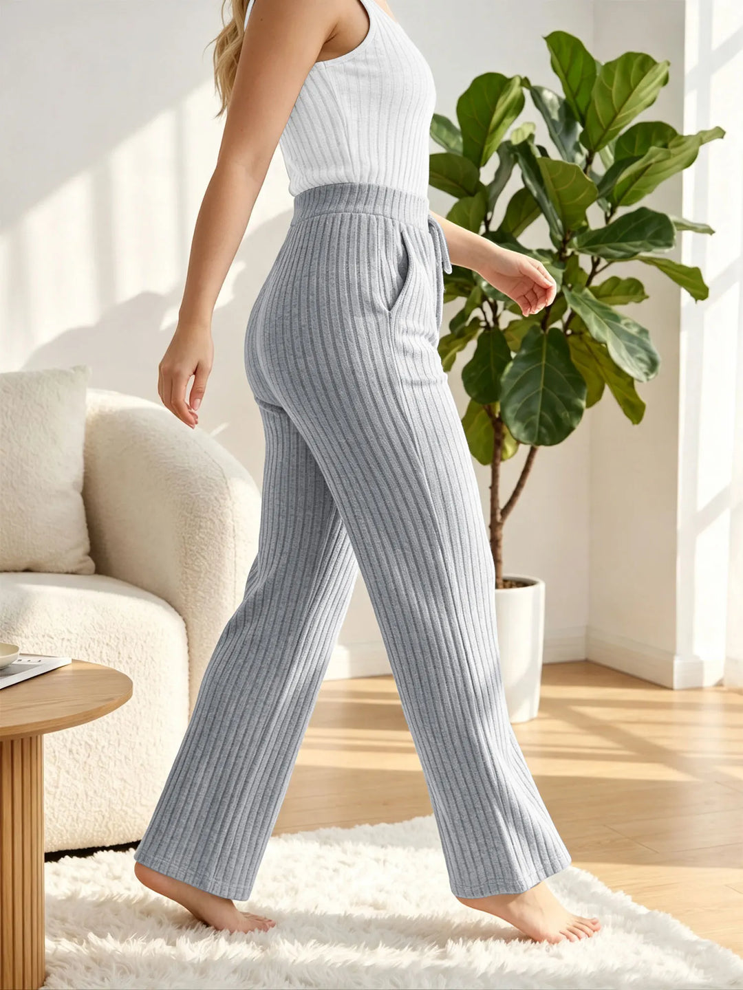 Light gray ribbed lounge pants shown from the side, with wide legs and a drawstring waist