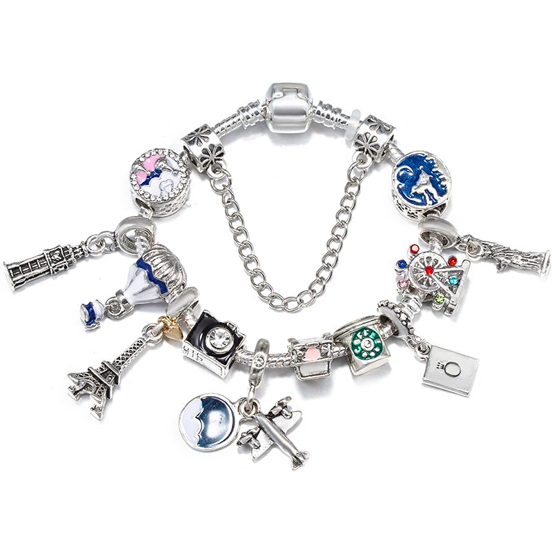 Silver charm bracelet with animal, city, and Eiffel Tower charms plus blue and green beads