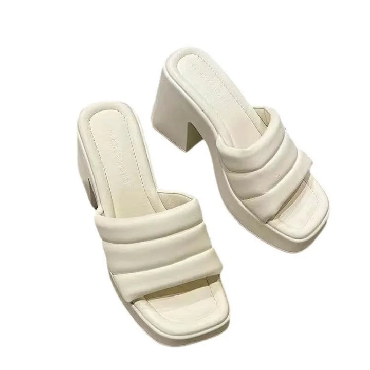 Pair of white sandals with a block heel on a white background