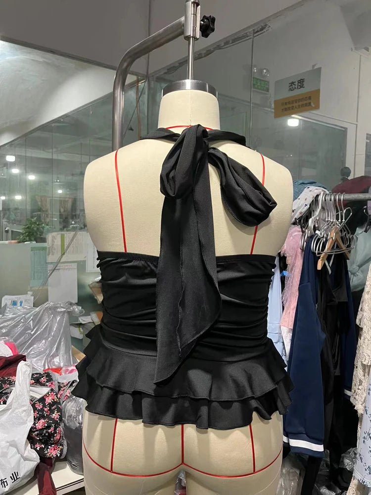 Black halter top with ruffles on a mannequin in a clothing store.