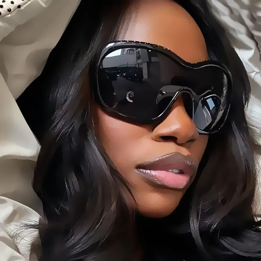 Woman wearing large black sunglasses with a neutral background