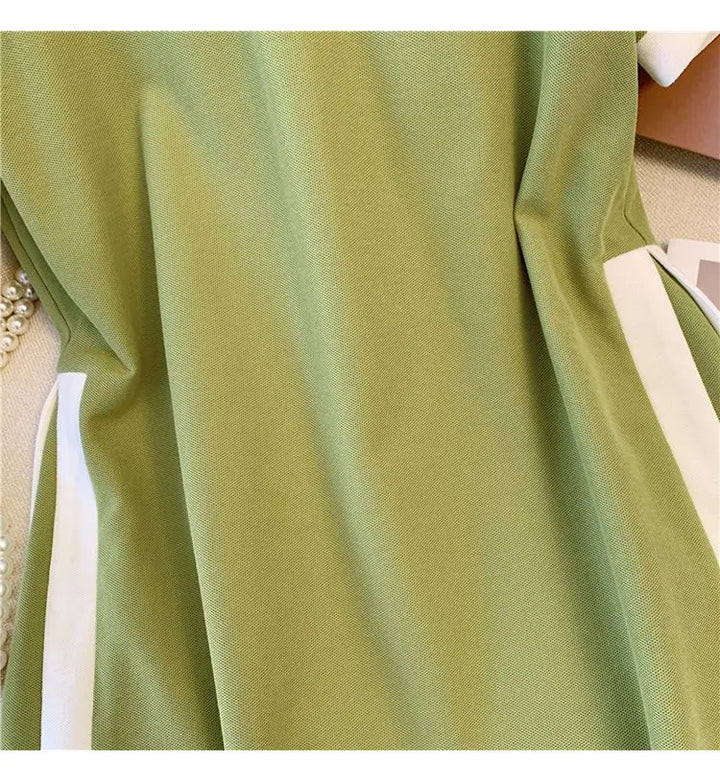 Green polo dress close-up of smooth fabric and white side trim