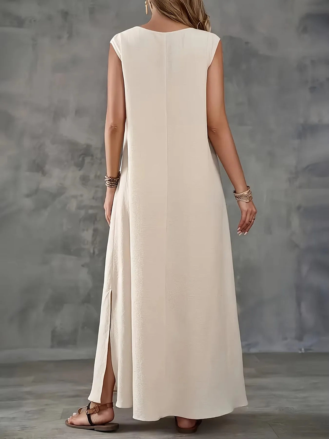 Beiges ärmelloses Maxikleid, Rückenansicht mit langem Schnitt und seitlichem Schlitz