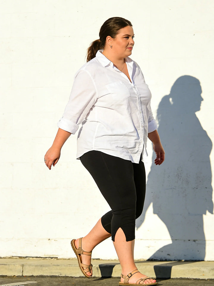 Black high-waist capri leggings with side slits, side view