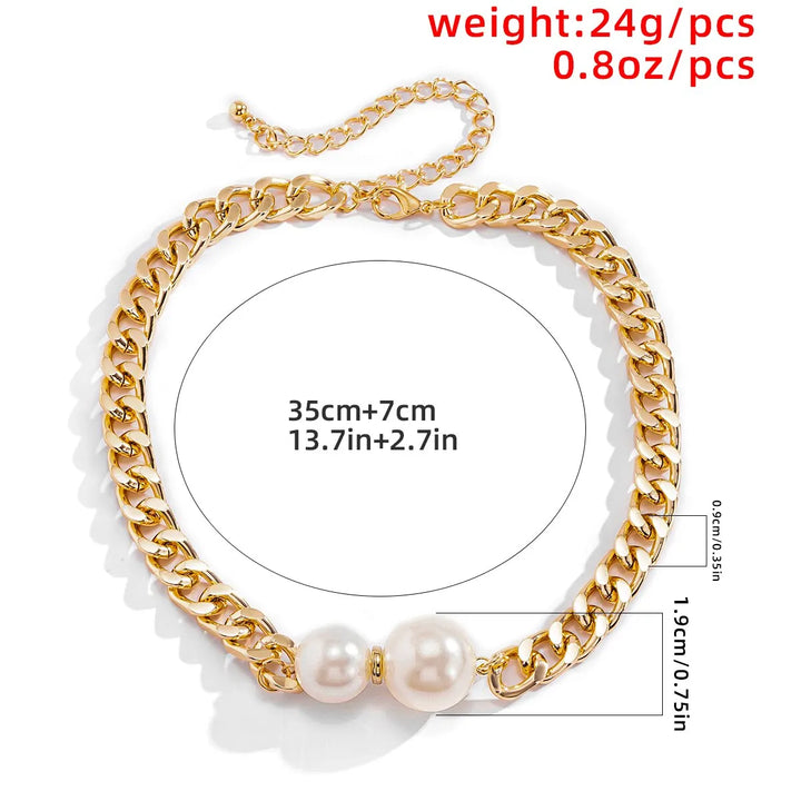 Gold chain necklace with pearls worn by a person in a white shirt.