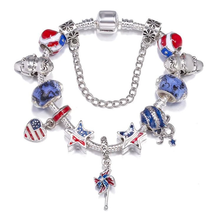 Silver charm bracelet with blue and red patriotic charm beads, stars, and a hanging flower