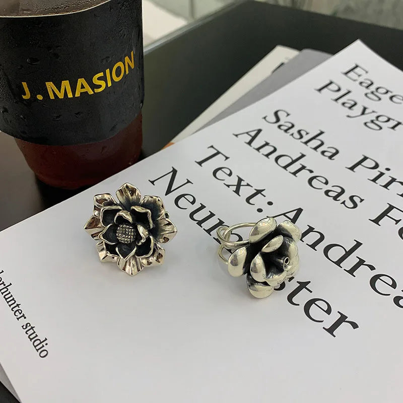 925 silver flower ring with textured dark center and engraved petal details, angled