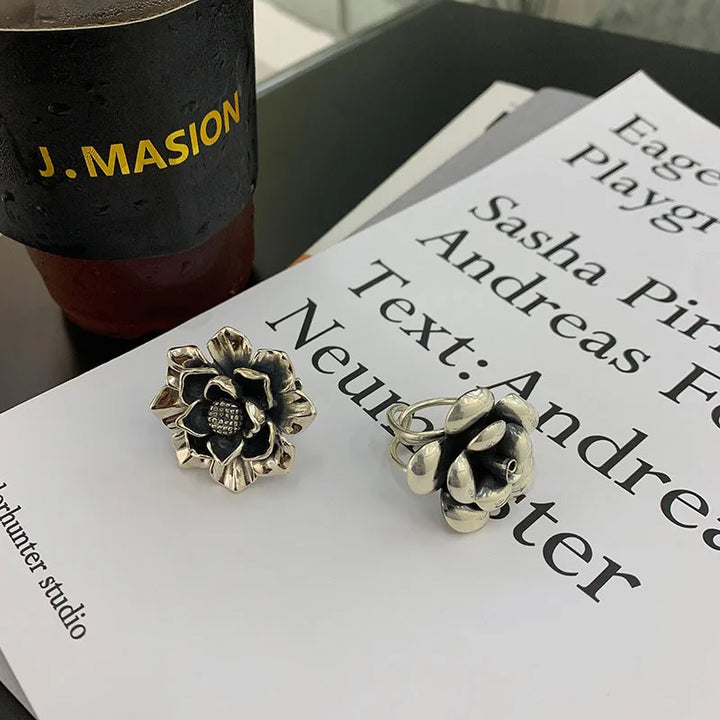 925 silver flower ring with textured dark center and engraved petal details, angled