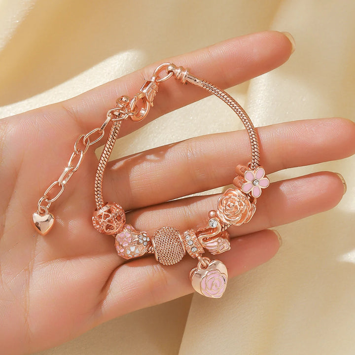 Rose gold beaded bracelet with small pink flower charm, rose bead, and pink heart links