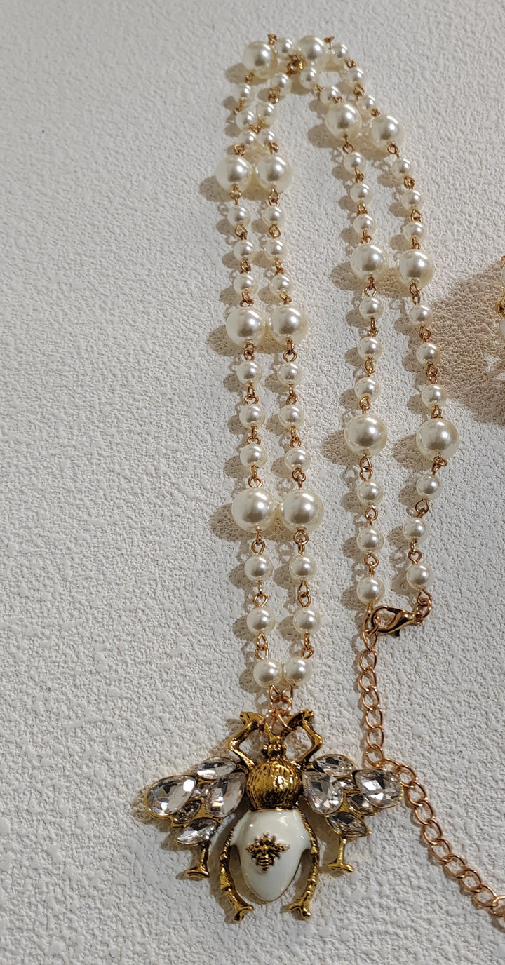 Pearl necklace with a decorative pendant on a light gray background