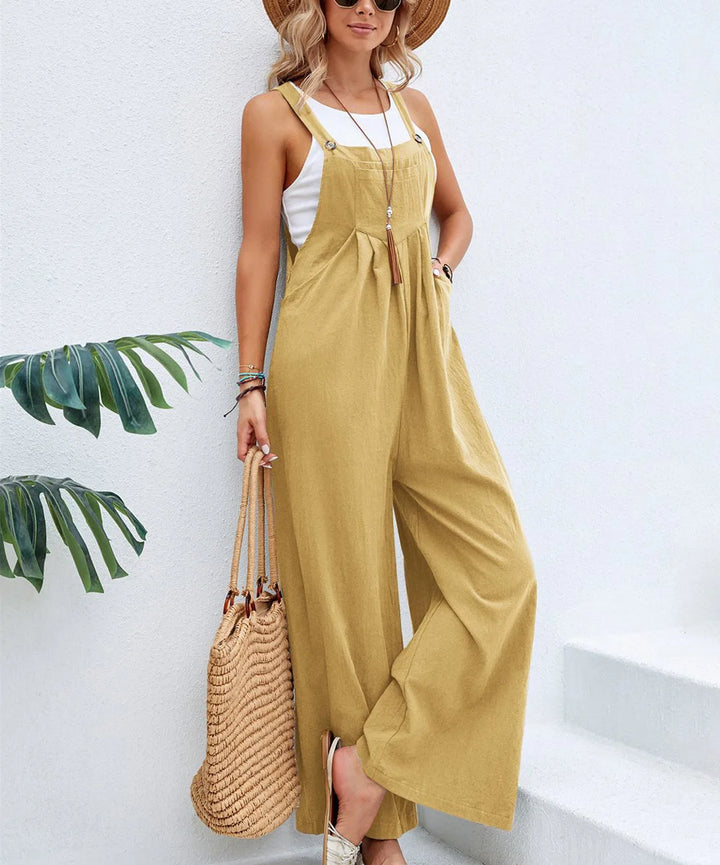 Yellow sleeveless jumpsuit with adjustable straps, tie-front detail, and wide-leg fit