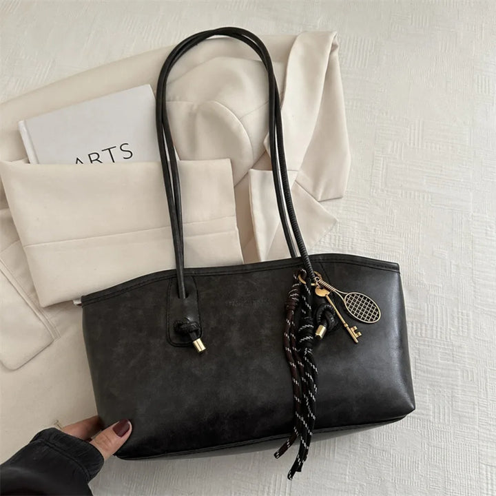 Black PU leather tote handbag with top handles and braided crossbody strap charm