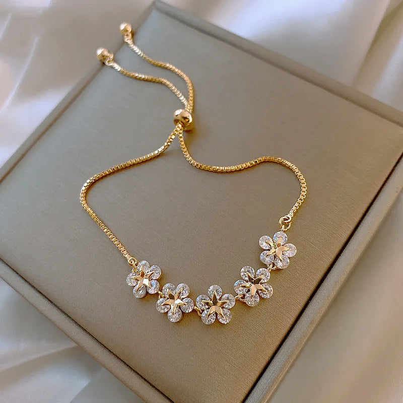 Gold-tone bracelet with flower-shaped clear stones on a linked chain