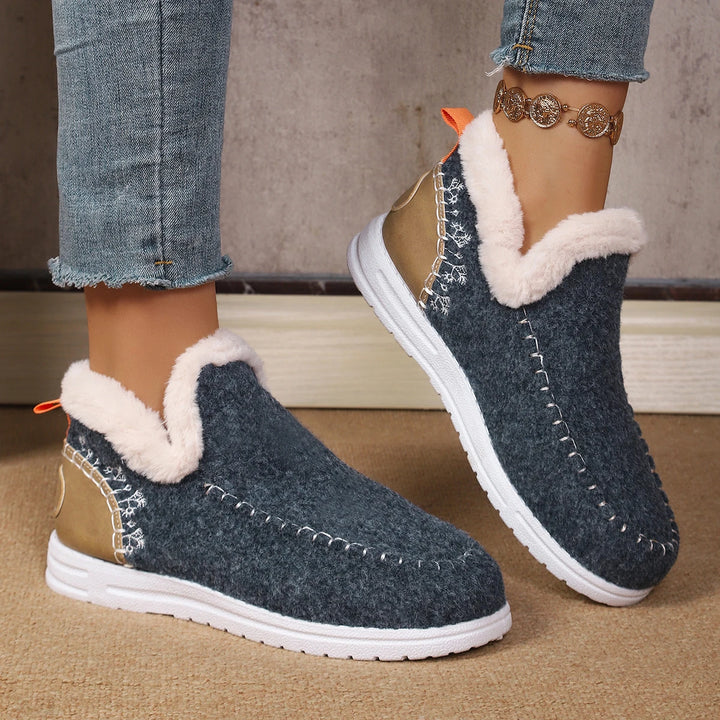 Women’s slip-on ankle snow loafer in dark navy felt, with white fuzzy collar and orange tag