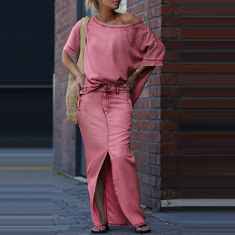 Woman wearing a pink outfit standing against a brick wall.